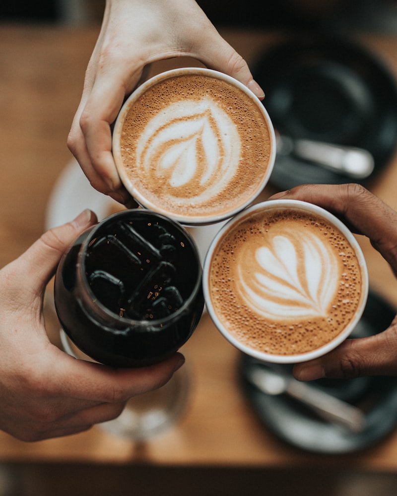 A ceramic mug of freshly brewed coffee with beans