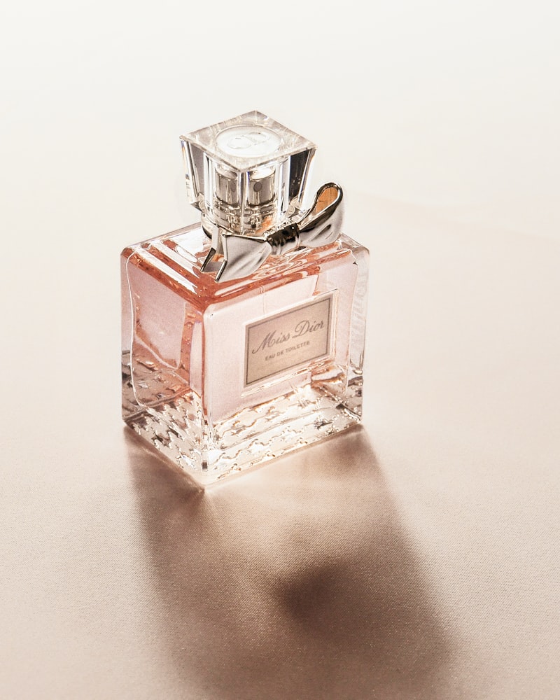 A glass perfume bottle on a marble surface