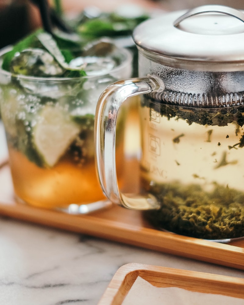 A glass teapot and loose leaf tea on a tray